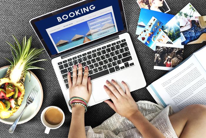 Computer on table surrounded by travel brochures