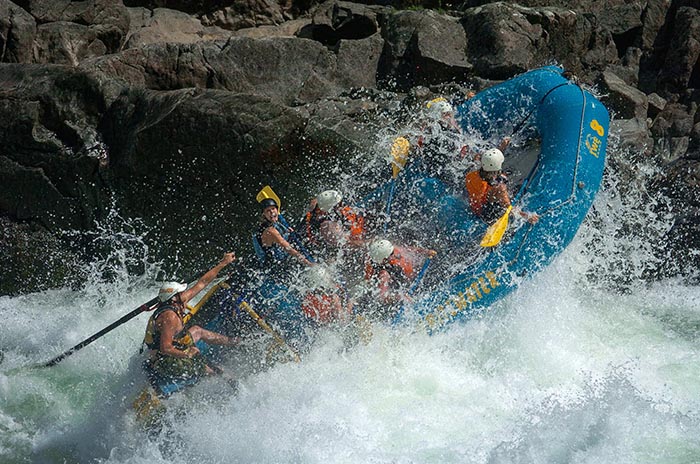 Blue raft with six people whitewater rafting