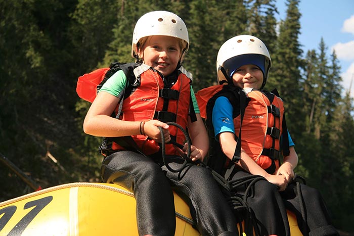 Two children sitting on a yellow raft