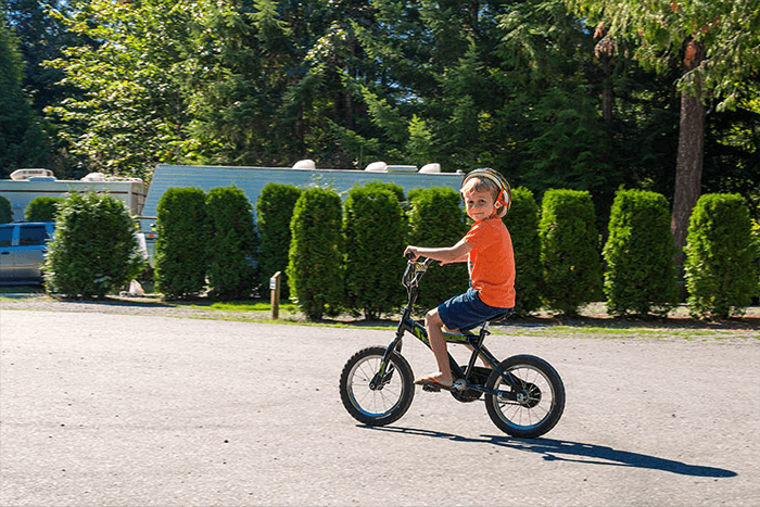 Child in orange shirt on bicycle at Rondalyn Resort