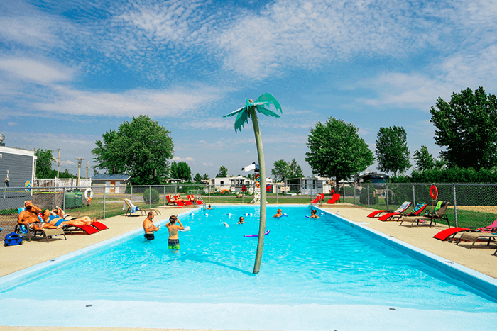 Swimming pool in campground surrounded by pool loungers