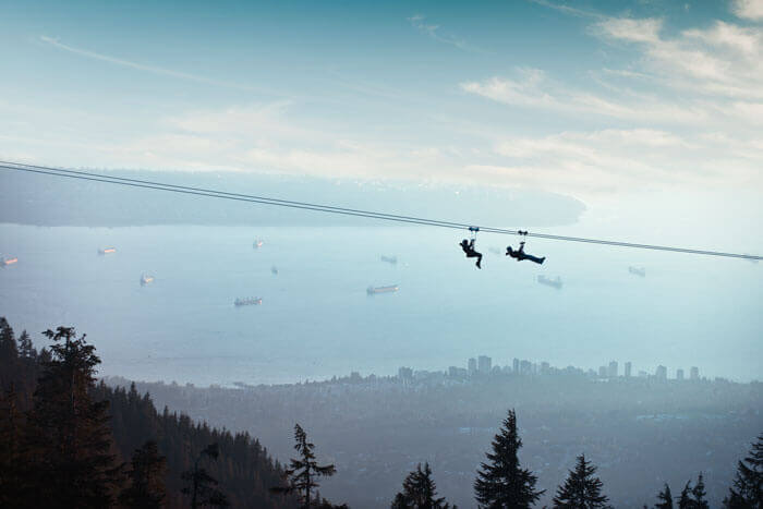 Mountain ziplines over trees at Grouse Mountain