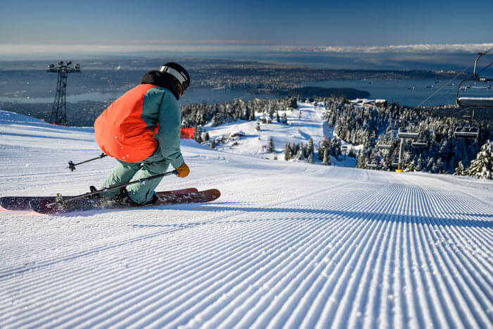 Skiier in orange jacket on slopes at Grouse Mountain