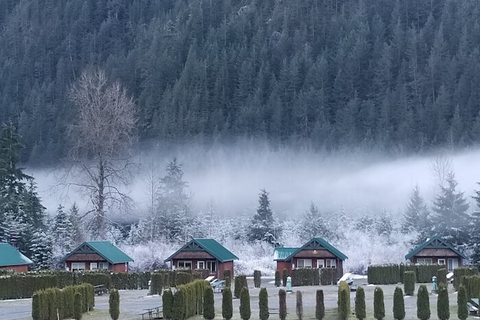 Mist over trees and cabins at Sunshine Valley RV Resort