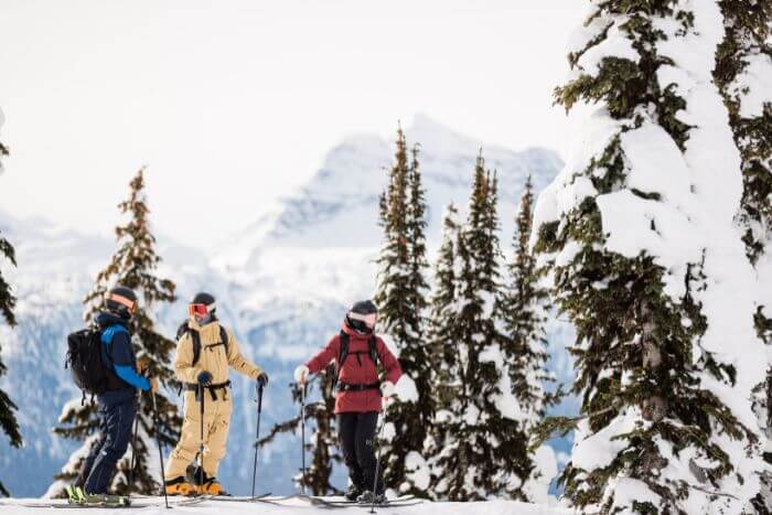 Trio on skis chatting before skiing down mountain