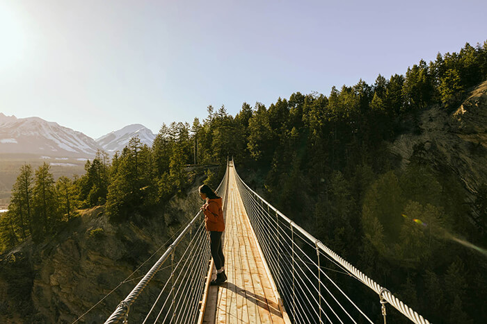 Woman standing on suspension bridge