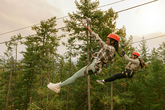 Two people on zipline above canyon