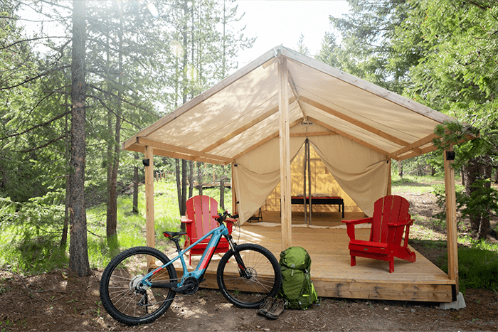 Glamping tent with bike and adirondak chairs