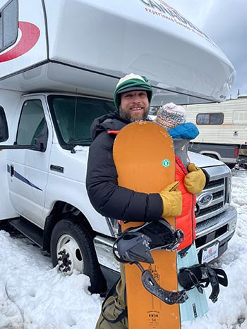 Man with snowboard and young child