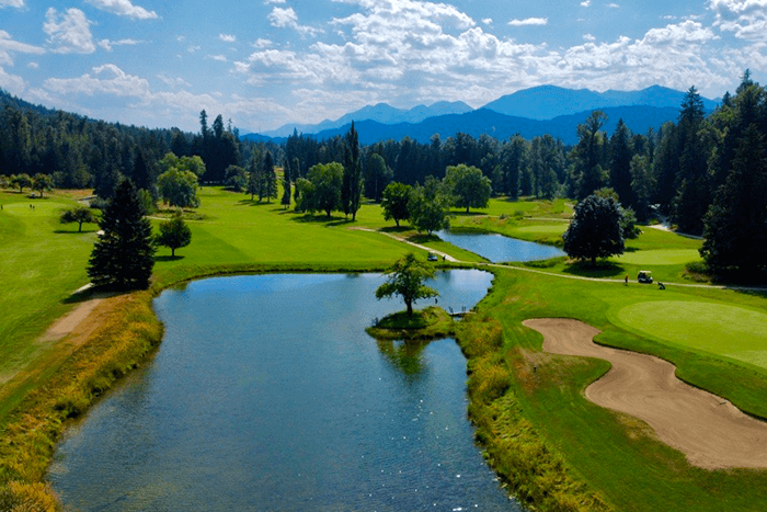 Golf Course, sand and water traps with trees and mountains in the background