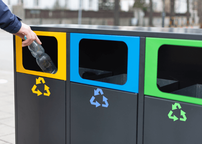 Man placing bottle in recycle bin