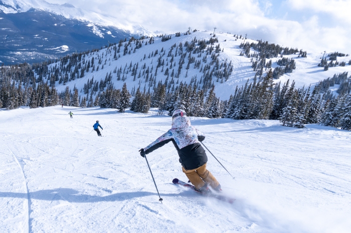 group of skiers ski down mountain