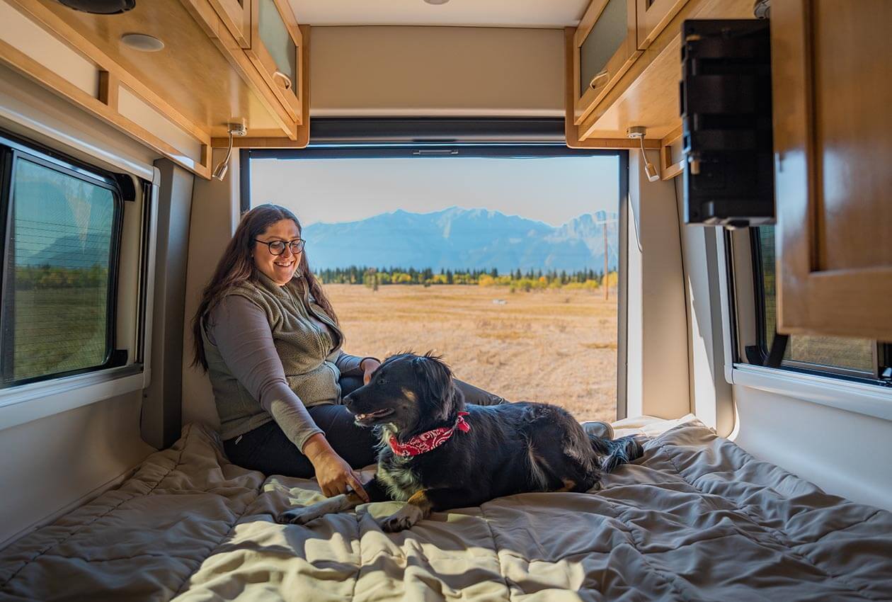 Girl Relaxing in the CanaDream Deluxe Van Camper with her dog