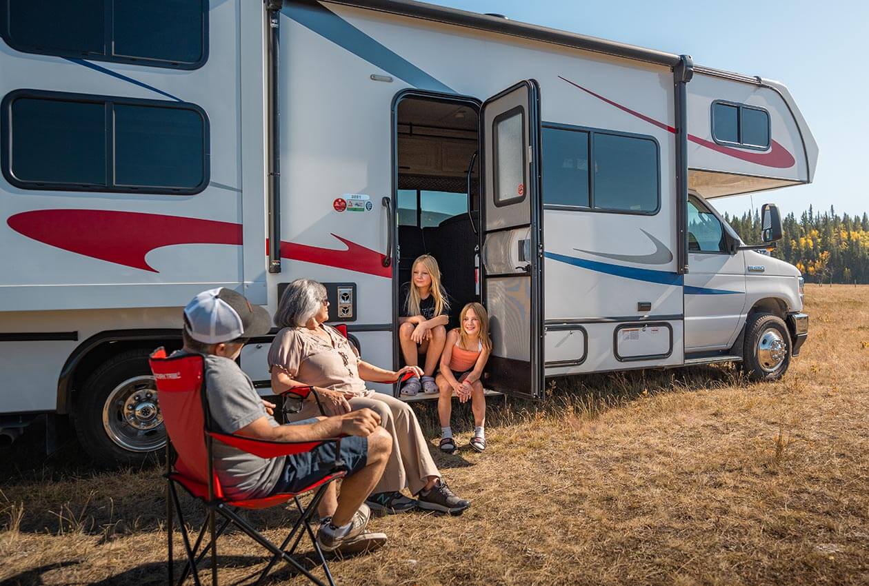 Family enjoying evening drinks beside CanaDream RV